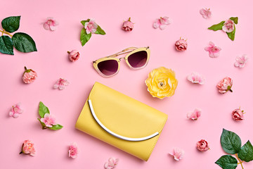 Fashion Woman Accessories Set. Pink Pastel Color. Flat lay. Minimal Style. Trendy fashion Yellow Clutch, Glamour Summer Sunglasses. Roses Flowers. Spring Floral