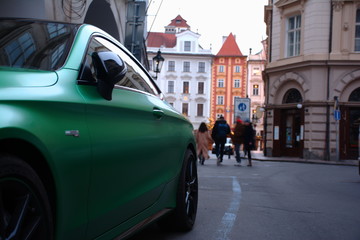 Nice green sport car in a Prague cityscape. Czech