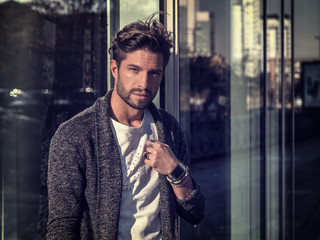 One handsome young man in urban setting in European city, standing