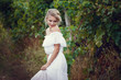 Beautiful blond girl with basket of grapes in a vineyard