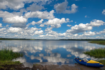 Naklejka na meble Inflatable tourist boat on the lake shore on a summer day
