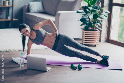 Fotografía Beautiful sporty cheerful woman is doing side plank exercise