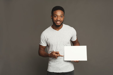 Wall Mural - Picture of young african-american man holding white blank board