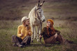 © Olena_Molchanova - Two charming young women rest on nature together with a cute donkey.
