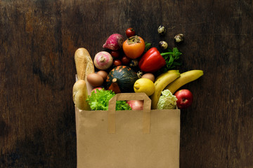 Canvas Print - Paper bag of different health food on dark wooden background