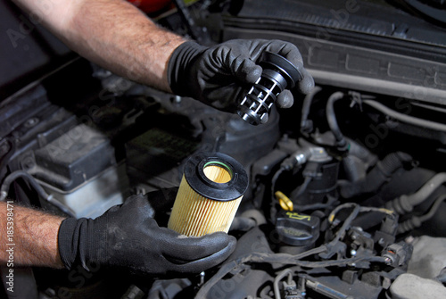 Fotografía mechanic in the hand, remove car oil filter