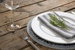 Fork, butter knife and wine glass with napkin and herb in a