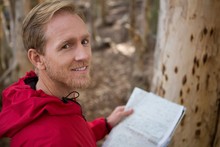 Young Hiker Man Looking Into Camera While Holding A Map In The