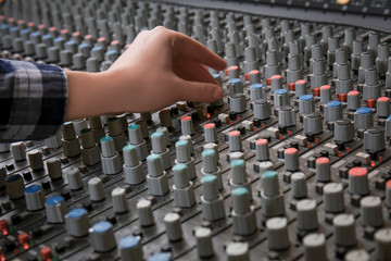 Radio host working with mixer in studio