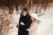 © Parilov - Happy couple having fun, smiling, kissing outdoors in winter against a forest background. Concept people, love, leisure in winter