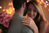 Fototapeta  - Happy couple dancing together against blurred lights on engagement day