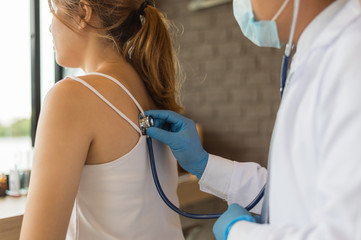 The doctor holding a stethoscope and put it on the woman patient's back at the Hospital. Concept of Healthcare, Medical treatment , examination