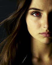 Portrait Of Beautiful Vampire Young Woman With Red Eyes.