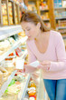 © auremar - Woman in the dairy section of the supermarket