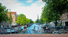 Channels And Vintage Bicycles On Amsterdam Street. The Capital Of The Netherlands On A Sunny Summer Day.
