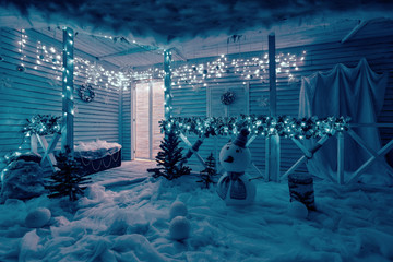 night light garlands. Christmas snowman decoration. The terrace with fir garlands