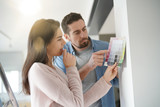 Fototapeta  - Couple looking at colour sample to renovate home interior