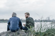 © Westend61 - Father and son meeting at Rhine river in autumn, talking together