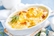 Baked potato gratin with garlic, cream and cheese, traditional french cuisine. White background