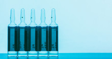 The Ampoules With Solution For Injections On A Blue Background With Space For Text,
