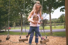 Mother And Daughter Playing On Playground With Equipment 