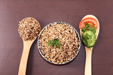 Cooked buckwheat. Healthy lunch. Brown background