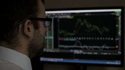 Businessman sitting and using computer showing trading graph stock exchange trading graph screen background, Business financial and forex concept. PC monitor showing blur  feed page .