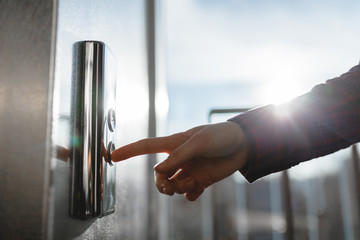 The thumb presses the Elevator button, a hand reaching for the button, the girl waiting for Elevator, push button start