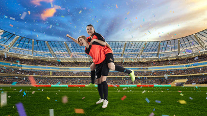 Wall Mural - two female soccer players celebrating victory on soccer filed