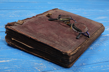 Glasses on the old closed Bible