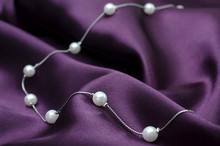 Silver Necklace Chain With Pearls Isolated On Silk