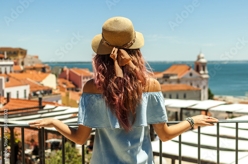 Plakat Młoda kobieta patrzeje Lisbon miasta panoramę Alfama na wycieczce