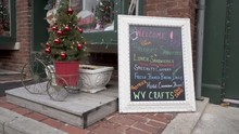 Steadicam Gimbal Shot Of Christmas Time Framed Welcome Sign On Street For Lunch, Snacks, Drinks.