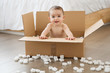 © Lisa Tichané - Portrait of baby boy sitting in cardboard box