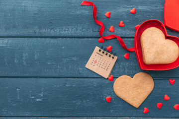 Wall Mural - Open heart shape gift box with cookies over wooden background. Happy valentines day. Love background