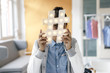 © Westend61 - Young woman hiding behind hashtag sign in studio