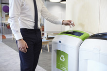 Man In An Office Throwing Plastic Bottle Into Recycling Bin