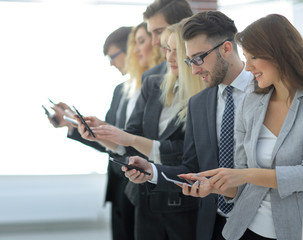 Canvas Print - business team looking at the screens of their smartphones