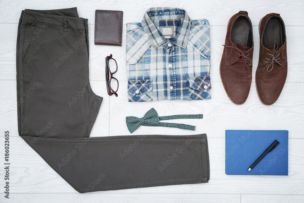 Set of hipster clothes and accessories on light background, top view