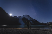 Couple Watching Moonrise Over Mount Robson From The Berg Lake In The Mount Robson Provincial Park, Canadian Rockies, British Columbia, Canada
