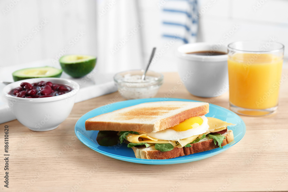 Plate with tasty toasts and fried egg on wooden table