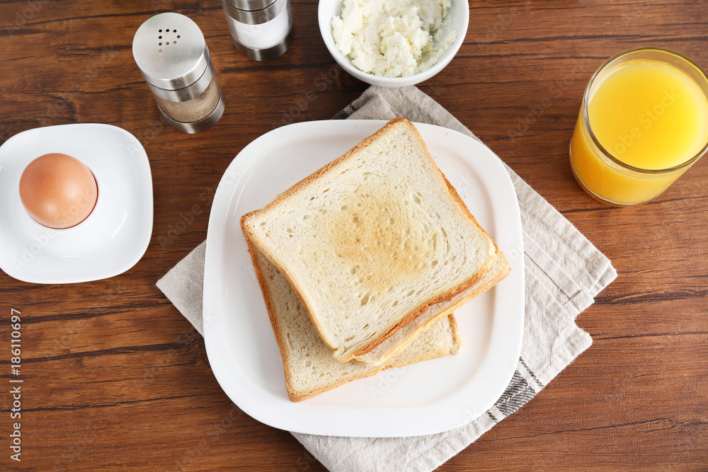Composition with toasts, cheese and boiled egg on wooden table