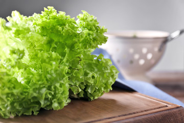 Bunch of fresh green salad on wooden board, closeup