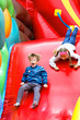 © Krugloff - Brother and sister have fun in the park on an inflatable slide