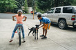 © Inti St. Clair - Boy petting dog in driveway, girl on bike