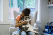 © Inti St. Clair - Girl hugging cat in living room