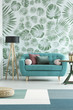 Blue sofa against leaves wallpaper