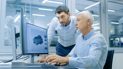 Industrial Designer Has Conversation with Senior Engineer While Working in CAD Program, Designing New Component. He Works on Personal Computer with Two Monitors.