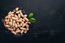 Peanuts On A Dark Wooden Background. Healthy Snacks. Top View. Free Space For Text.