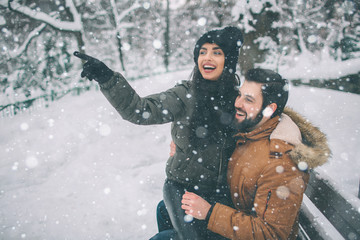 happy young couple in winter . family outdoors. man and woman looking upwards and laughing. love, fu